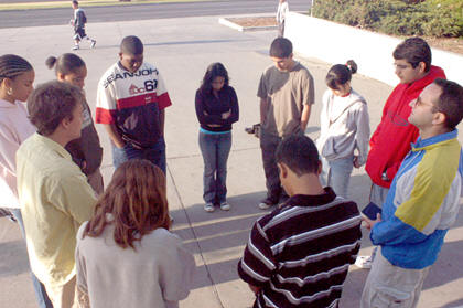 teens praying at school flagpole